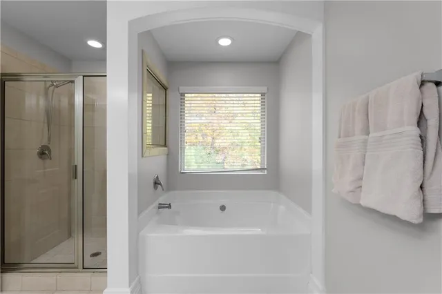 a bathroom with a bathtub a shower and a sink