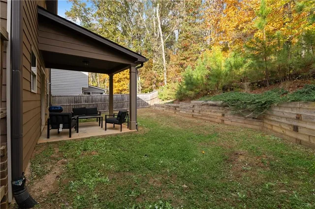 a view of a backyard with table and chairs and floor to ceiling window