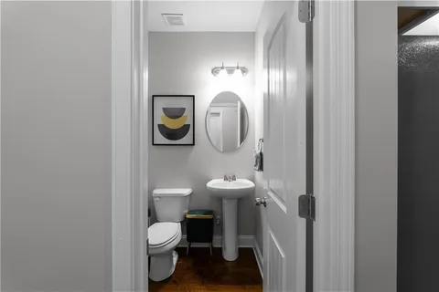 a bathroom with a toilet a sink and mirror