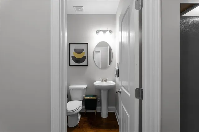 a bathroom with a toilet a sink and mirror
