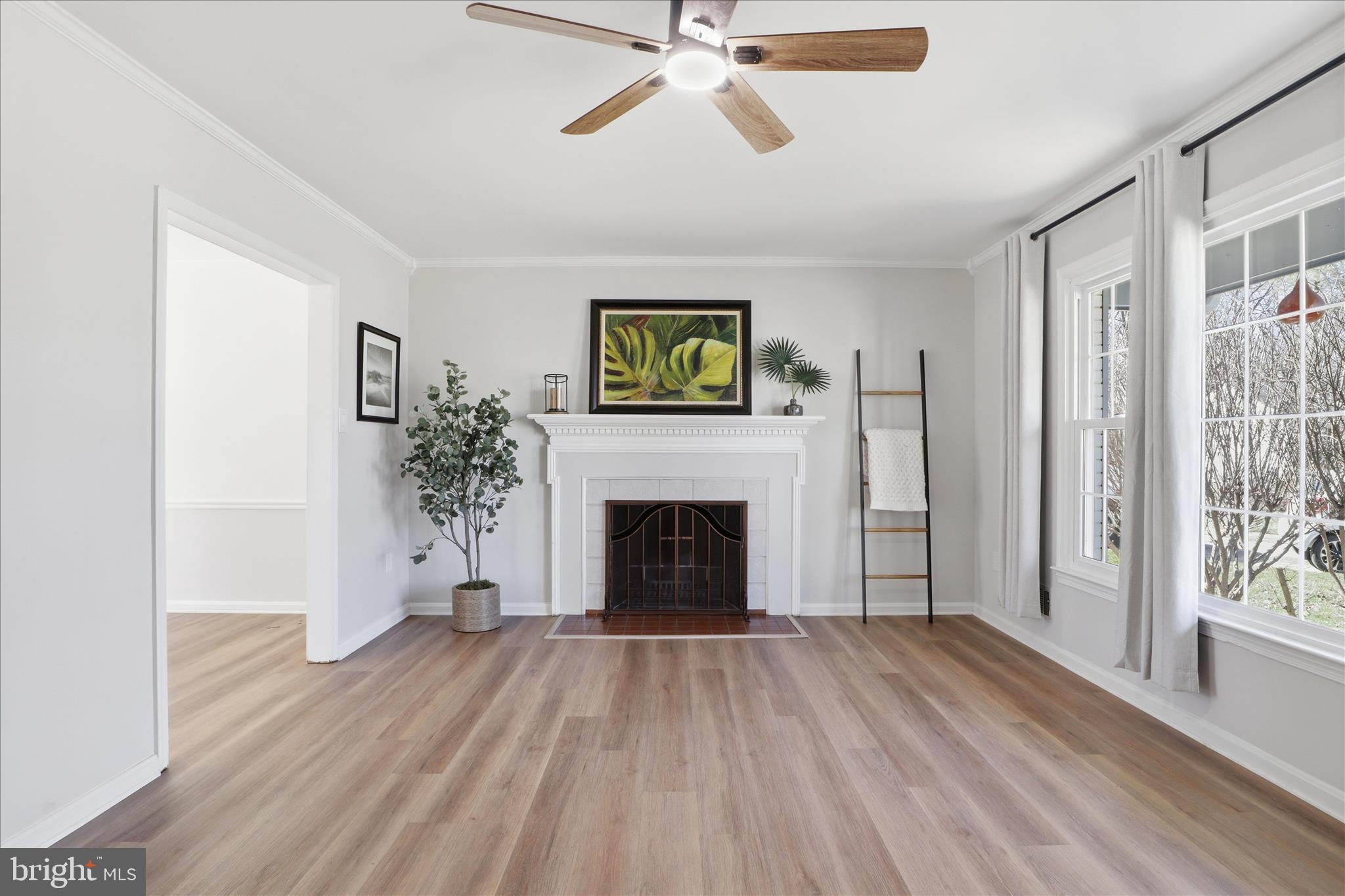 a view of a livingroom with a fireplace wooden floor and windows