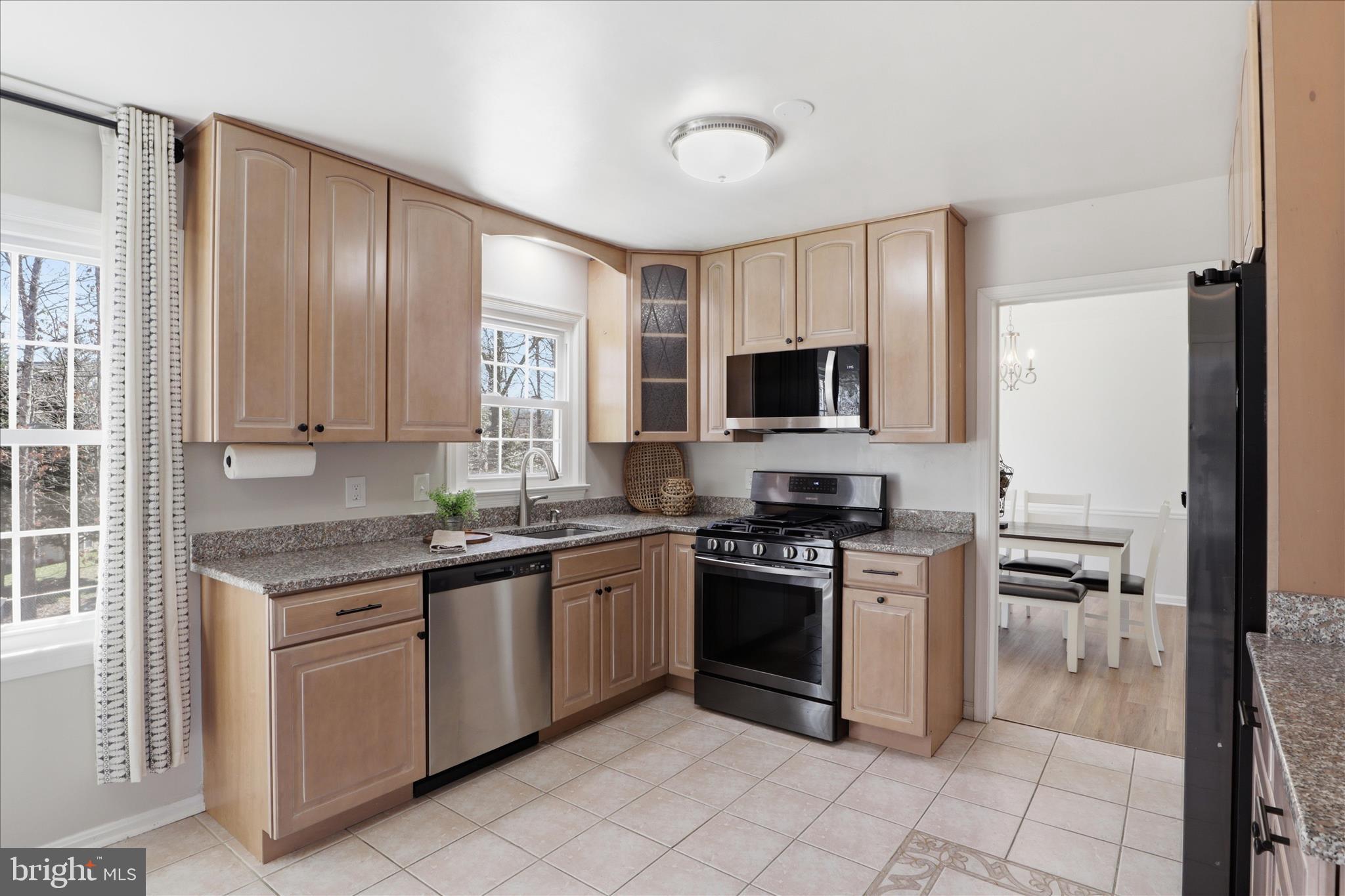 8109 Overton Court Springfield, VA 22153 - Photo 9 of 38 a kitchen with stainless steel appliances granite countertop a stove top oven a sink dishwasher a refrigerator and a microwave