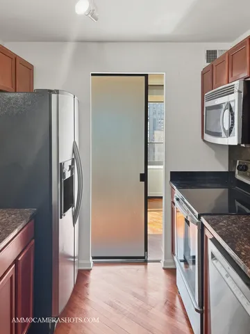 a kitchen with stainless steel appliances granite countertop a refrigerator and a sink
