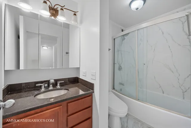 a bathroom with a granite countertop sink toilet and shower