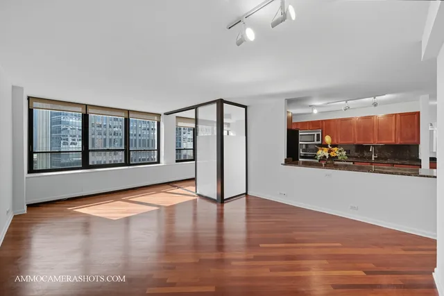 a view of an empty room with a window and wooden floor