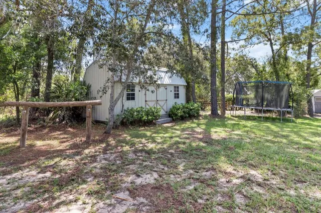 an aerial view of residential house with outdoor space and trees all around