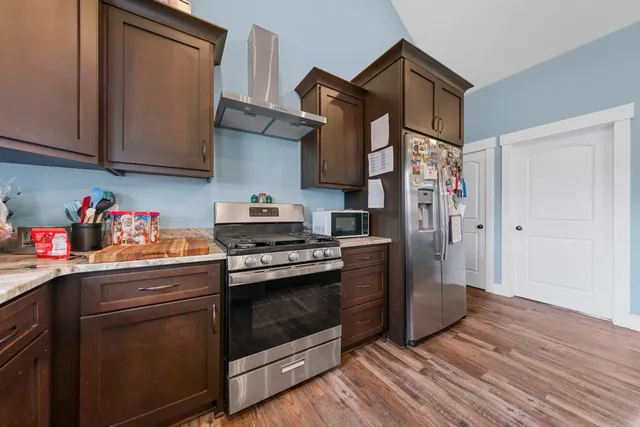 a kitchen with stainless steel appliances granite countertop a stove and a refrigerator