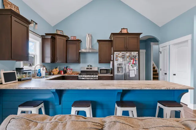 a kitchen with stainless steel appliances granite countertop a stove a sink and a microwave