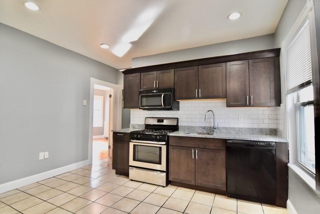 21 Treadway Road, Unit 2 Boston, MA 02125 - Photo 15 of 21 a kitchen with stainless steel appliances granite countertop a stove a sink and a refrigerator