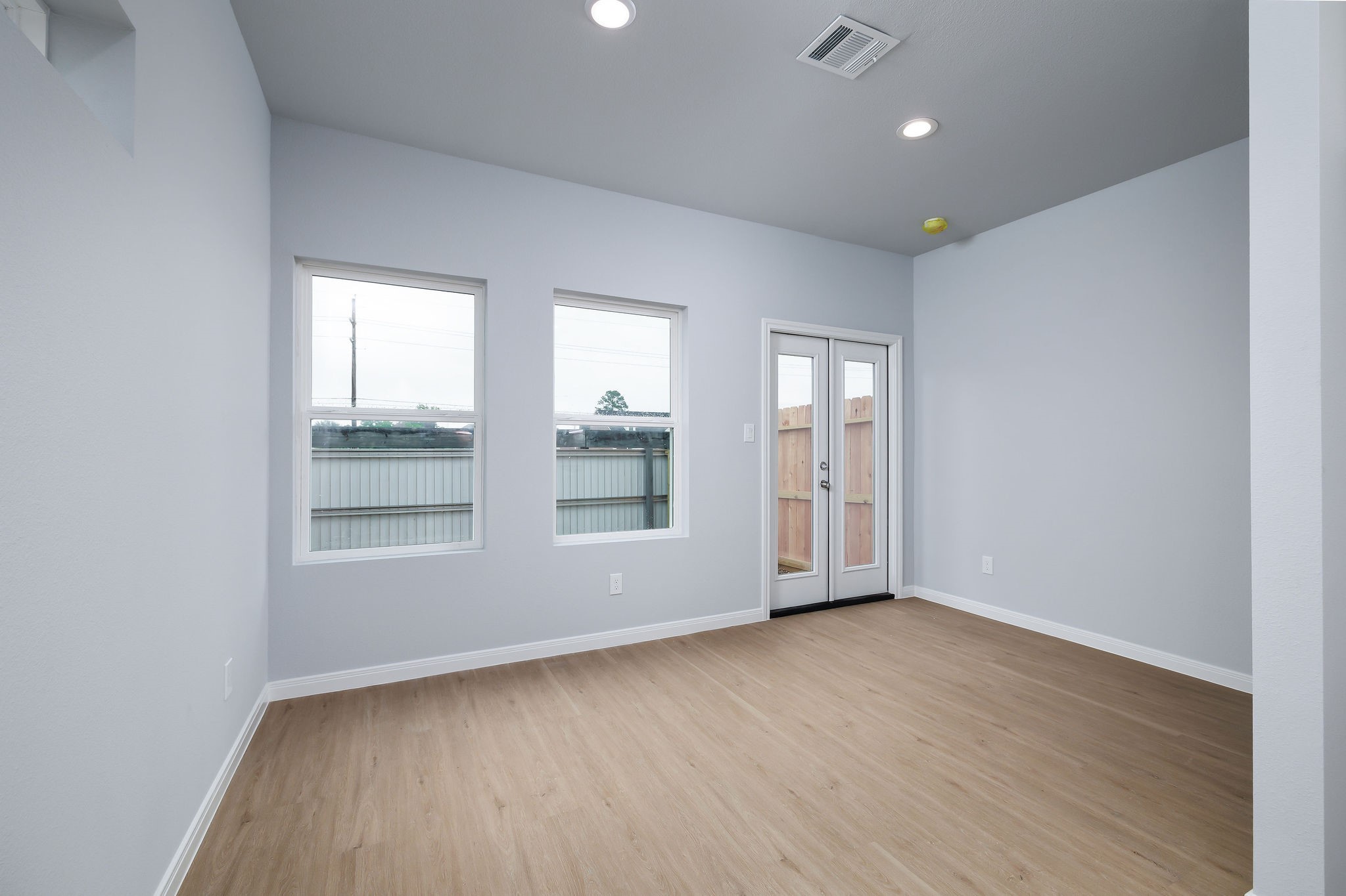 18834 Elegance Ave Spring Spring, TX 77379 - Photo 8 of 19 an empty room with wooden floor and windows