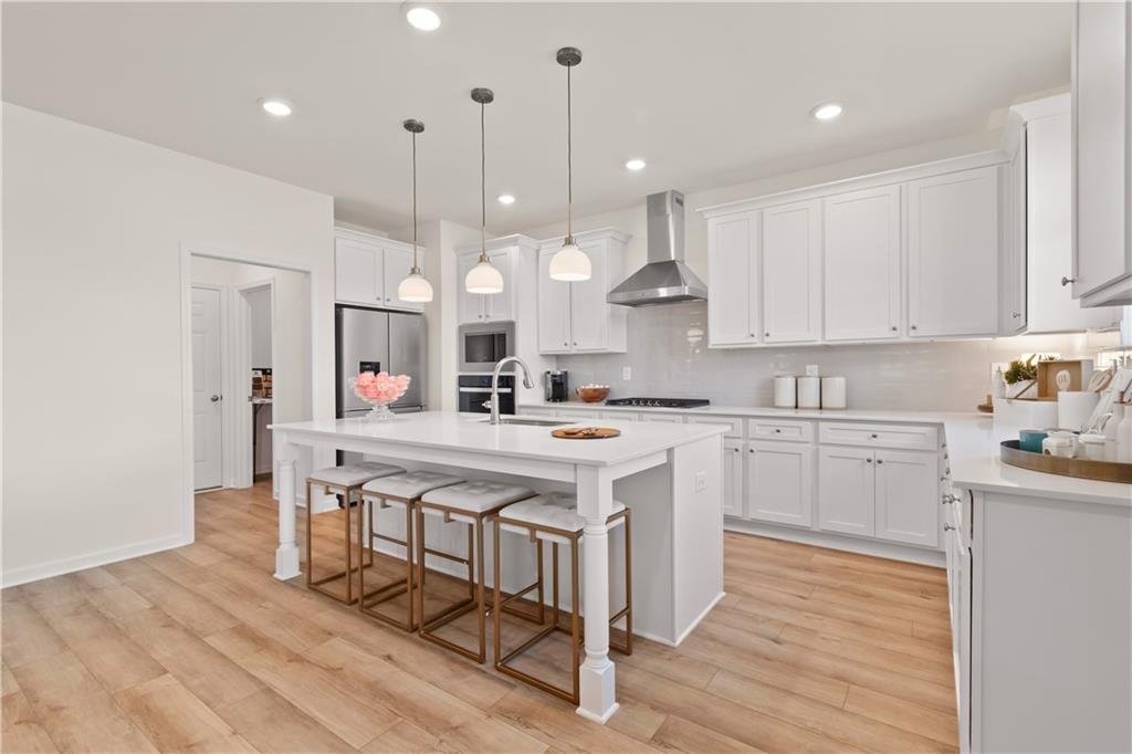 295 Abbotts Xing Circle Covington, GA 30016 - Photo 16 of 34 a kitchen with white cabinets and white appliances