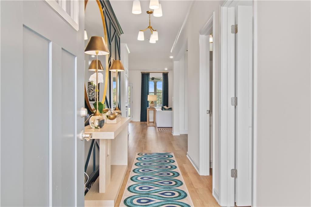 295 Abbotts Xing Circle Covington, GA 30016 - Photo 2 of 34 a hallway with dining area and chandelier