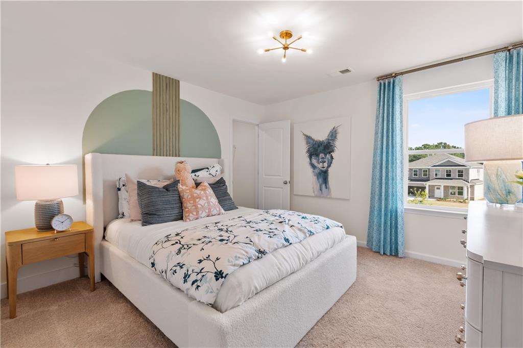 295 Abbotts Xing Circle Covington, GA 30016 - Photo 21 of 34 a bedroom with a bed and a chandelier