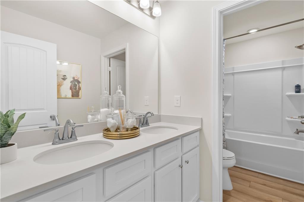295 Abbotts Xing Circle Covington, GA 30016 - Photo 23 of 34 a bathroom with a granite countertop sink and a mirror