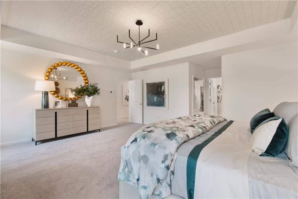 295 Abbotts Xing Circle Covington, GA 30016 - Photo 27 of 34 a bedroom with a bed and a chandelier