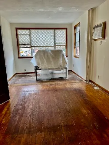 a view of a livingroom with wooden floor and a window