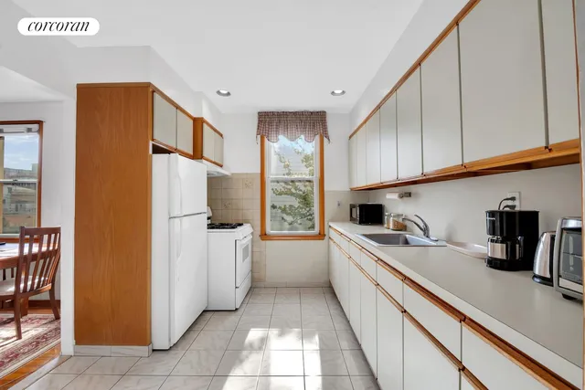 a kitchen with a sink a refrigerator and cabinets