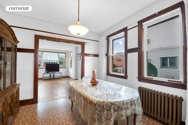a dining room with wooden floor and large windows
