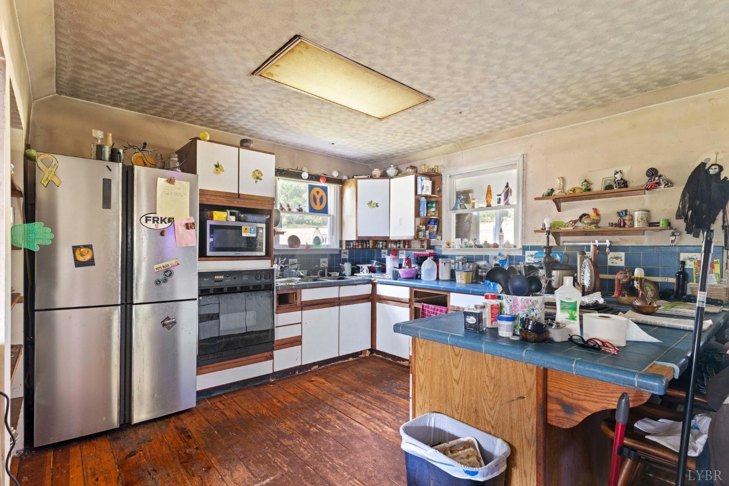 1095 Blacks Creek Road Lexington, VA 24450 - Photo 32 of 35 a kitchen with stainless steel appliances kitchen island granite countertop a refrigerator a stove and white cabinets with wooden floors