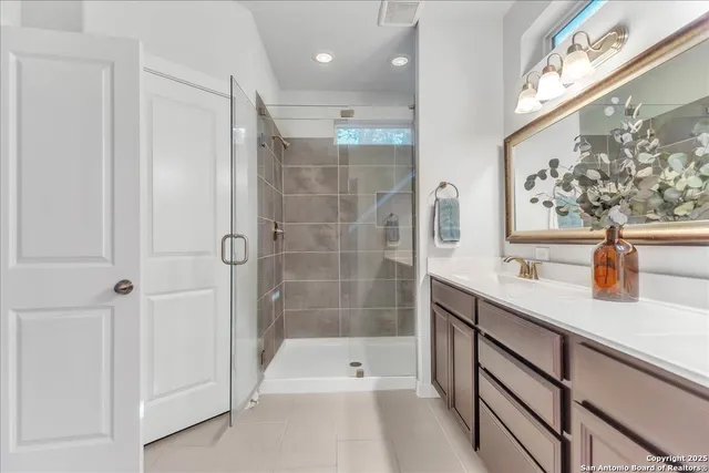 a bathroom with a sink and mirror with bathtub
