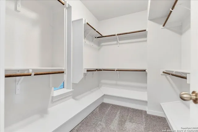 a spacious bedroom with a bed and a chandelier