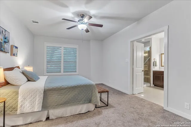 a spacious bedroom with a bed and a chandelier