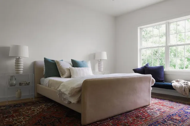 a living room with a bed and a window