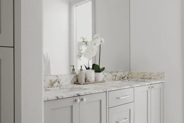 a bathroom with a granite countertop sink and a mirror