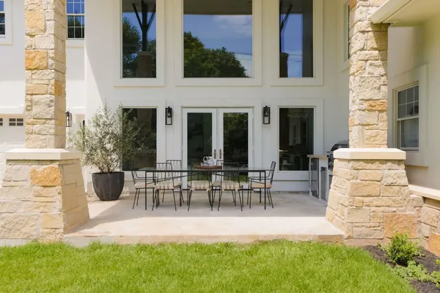 a view of two chairs and table in backyard