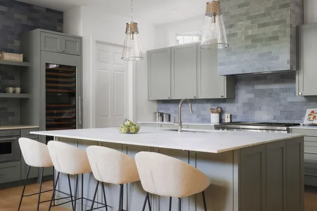 a kitchen with stainless steel appliances granite countertop a table chairs in it and wooden floors