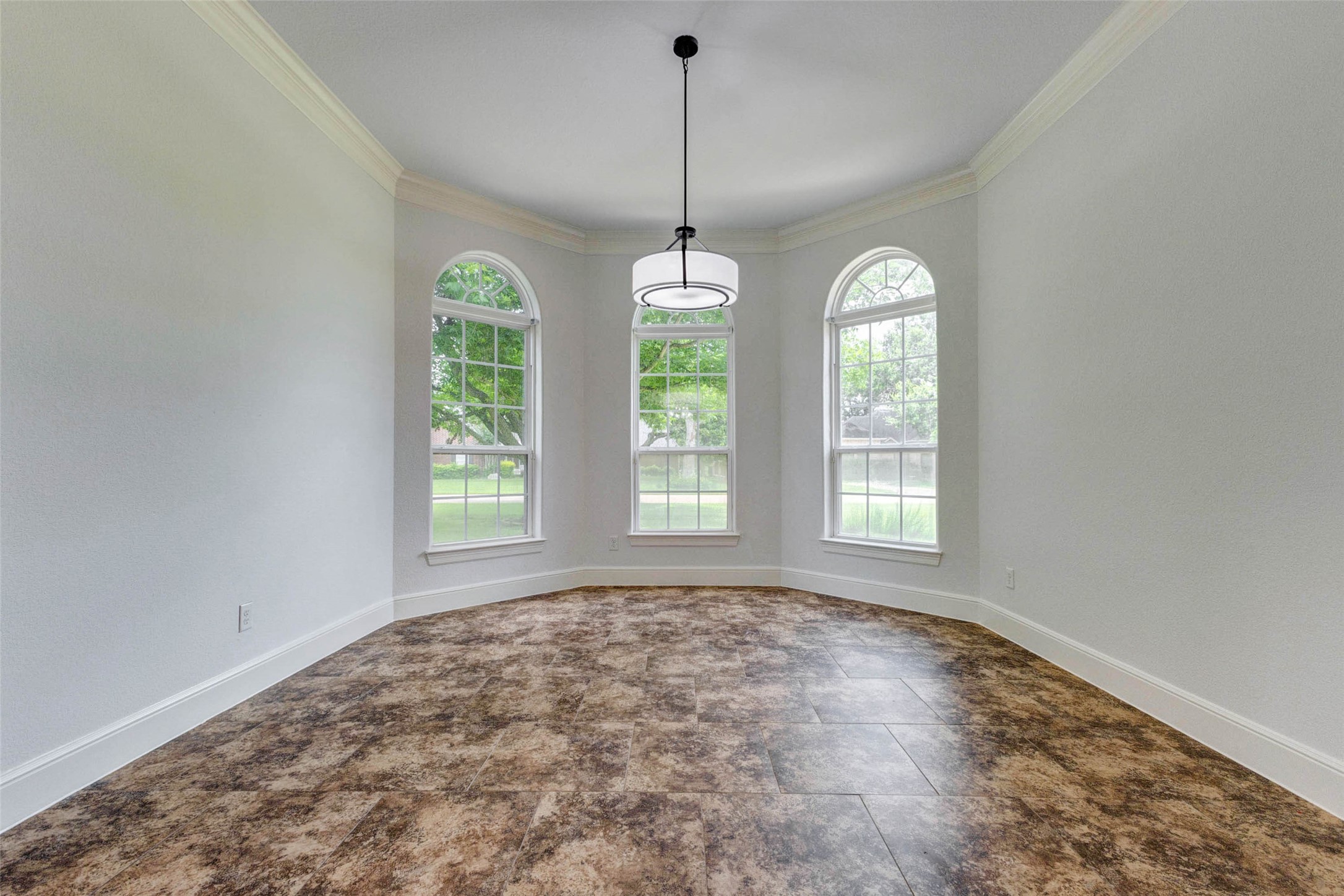 5327 Whitmore Fulshear, TX 77441 - Photo 19 of 50 Framed by graceful arched windows and enhanced by crown molding, the formal dining room offers a sophisticated setting for holiday gatherings, intimate dinners, and celebrations both large and small.