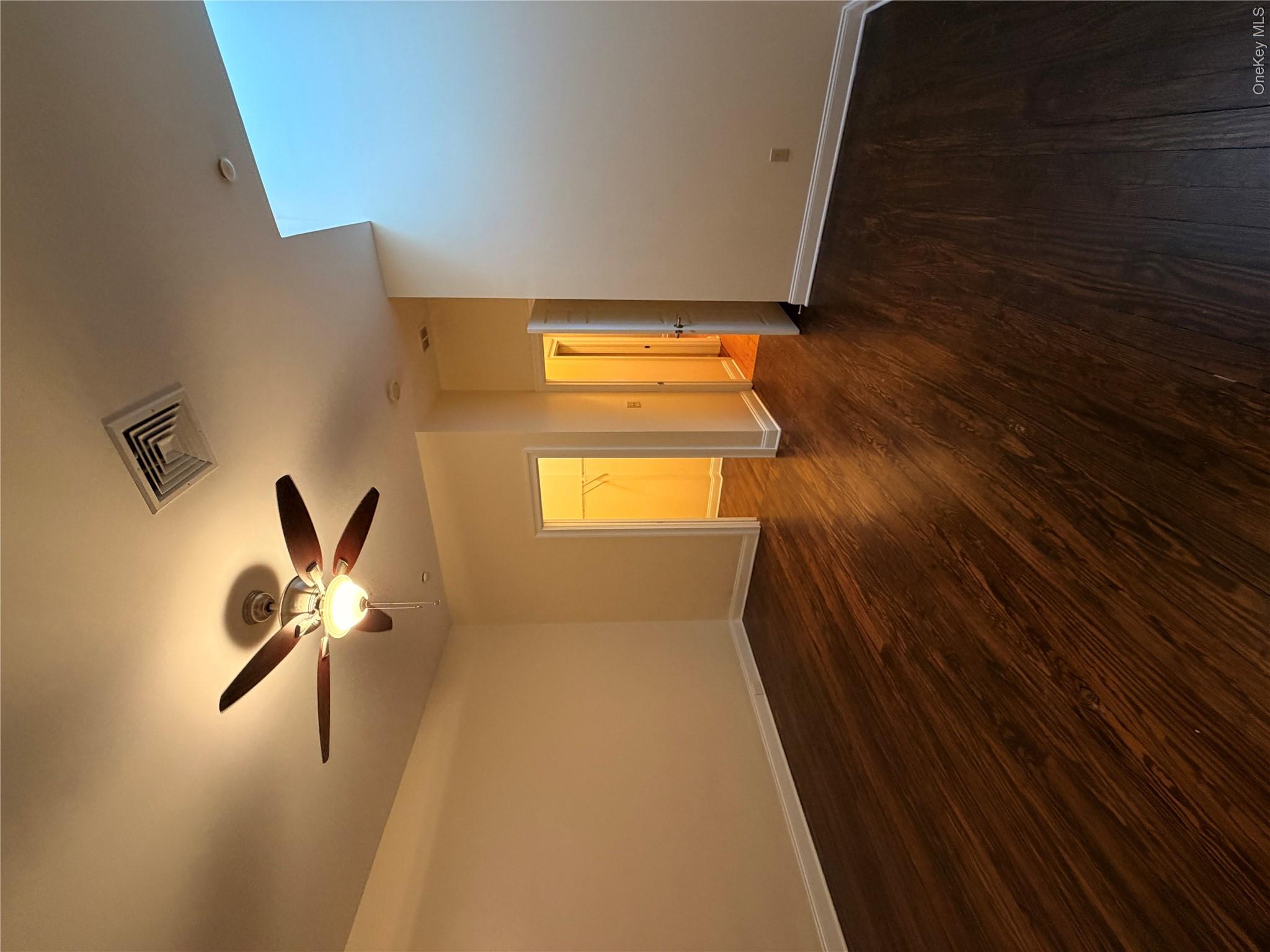 337 Main Street, Unit 3F Poughkeepsie, NY 12601 - Photo 7 of 9 a view of an empty room with wooden floor and a ceiling fan