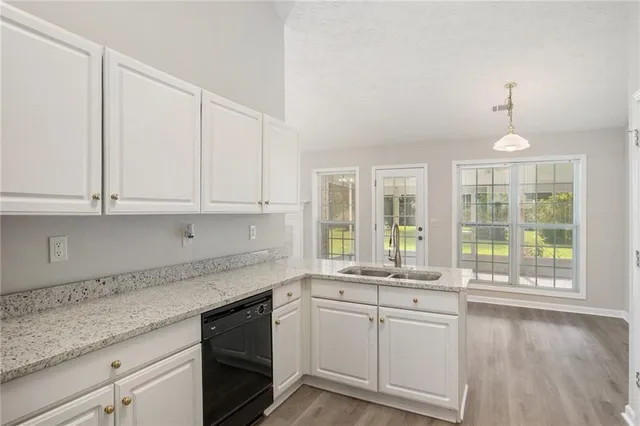 a kitchen with granite countertop white cabinets and a large window