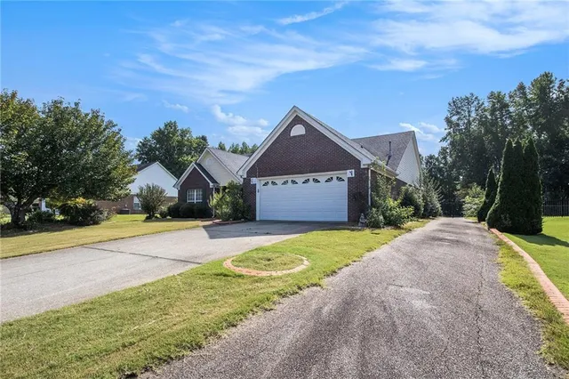 a front view of a house with a yard and trees