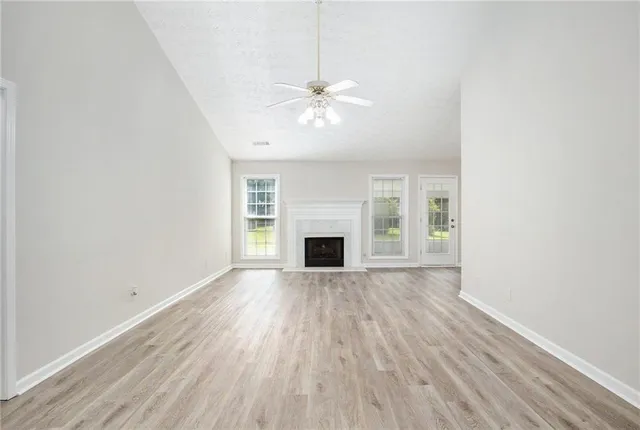 a view of a room with wooden floor and a fireplace