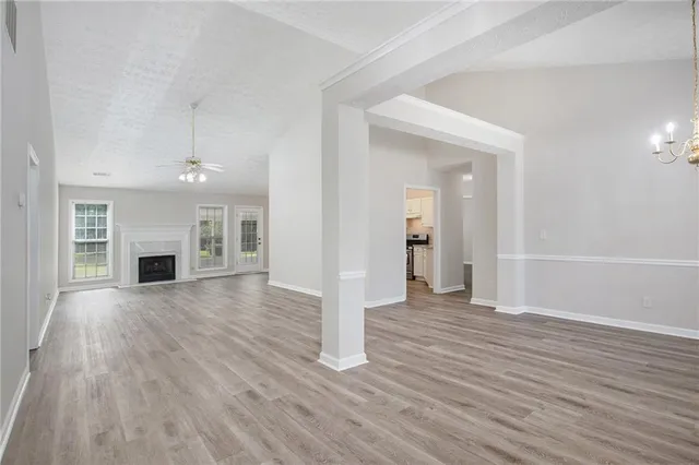 an empty room with wooden floor and fireplace