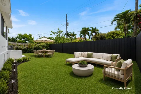 a view of a backyard with couches table and chairs and potted plants