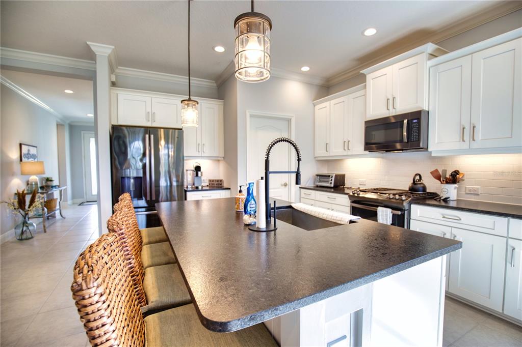 Undisclosed Address Venice, FL 34293 - Photo 11 of 45 a kitchen with stainless steel appliances granite countertop a dining table chairs refrigerator and microwave