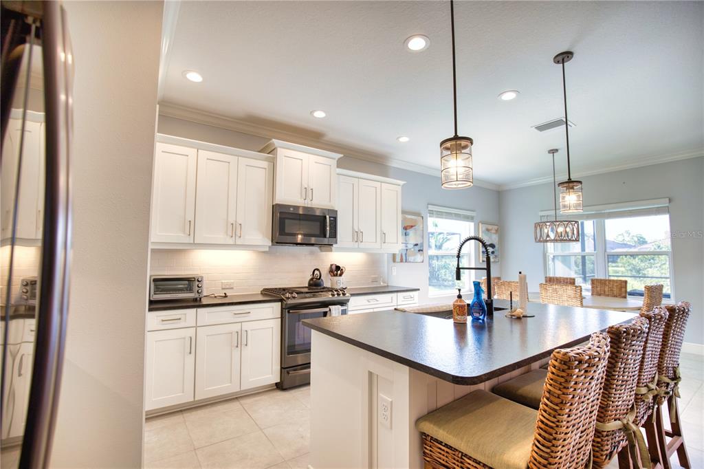 Undisclosed Address Venice, FL 34293 - Photo 12 of 45 a kitchen with stainless steel appliances kitchen island granite countertop a sink a stove and cabinets