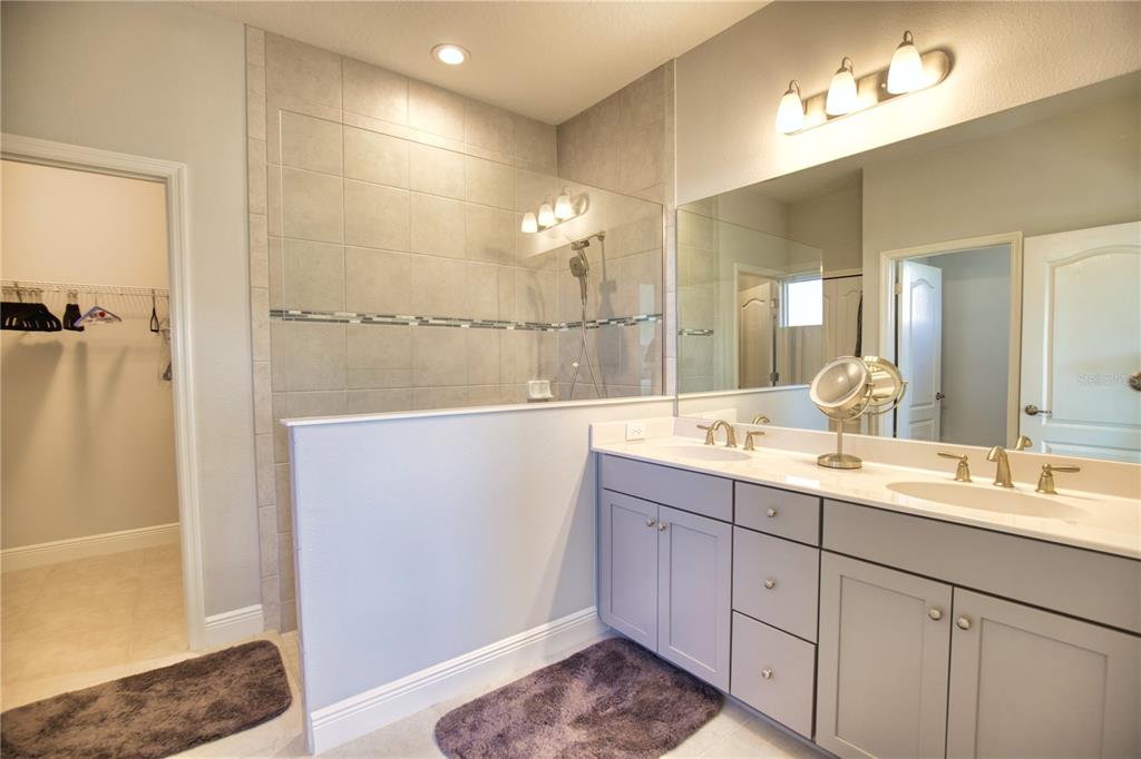 Undisclosed Address Venice, FL 34293 - Photo 20 of 45 a bathroom with a double vanity sink a mirror and shower