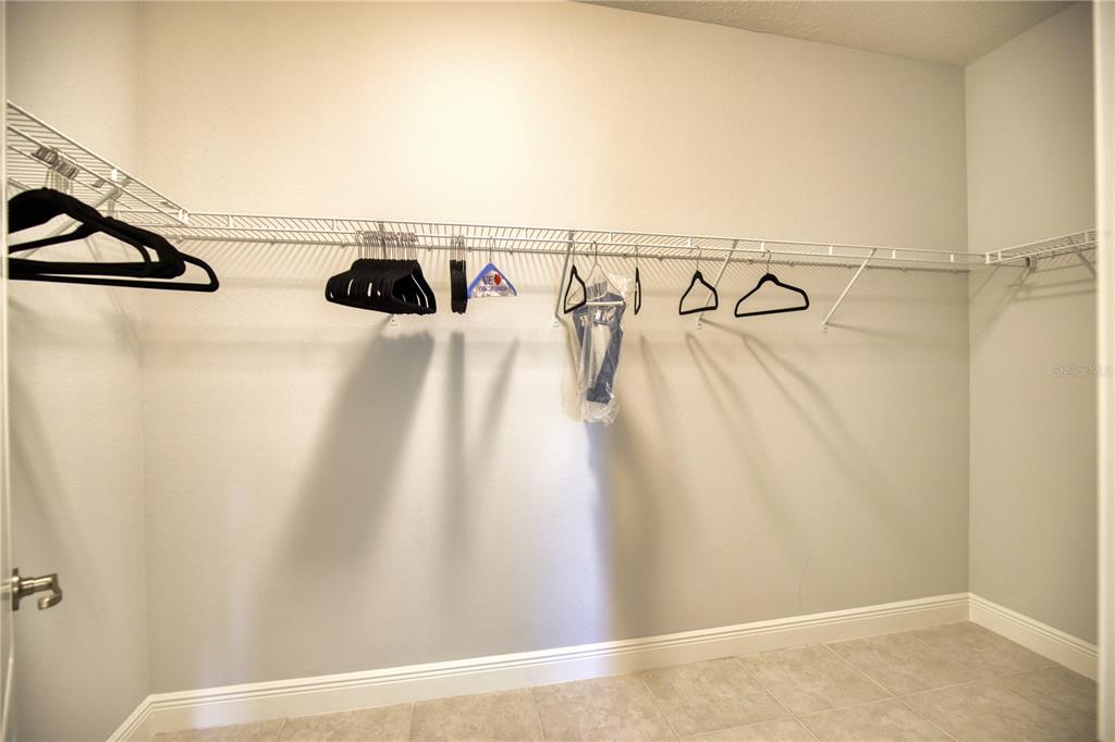Undisclosed Address Venice, FL 34293 - Photo 21 of 45 a view of walk in closet with clothes and shoes