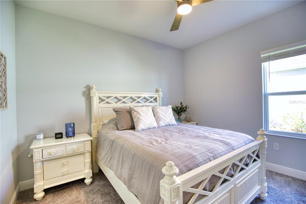 Undisclosed Address Venice, FL 34293 - Photo 23 of 45 a bedroom with a bed and a chandelier fan