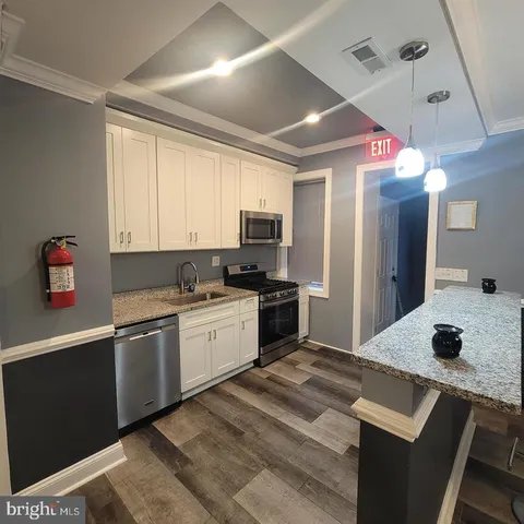 a kitchen with granite countertop a sink cabinets and window