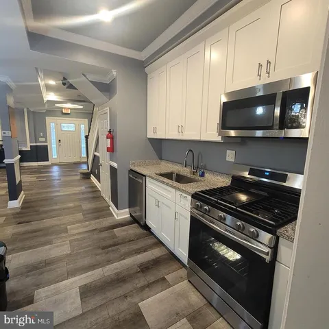 a kitchen with stainless steel appliances kitchen island granite countertop a stove and a microwave