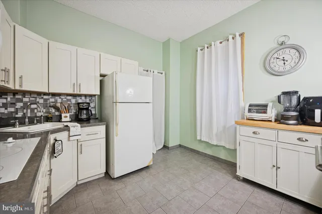 a kitchen with white cabinets and white appliances