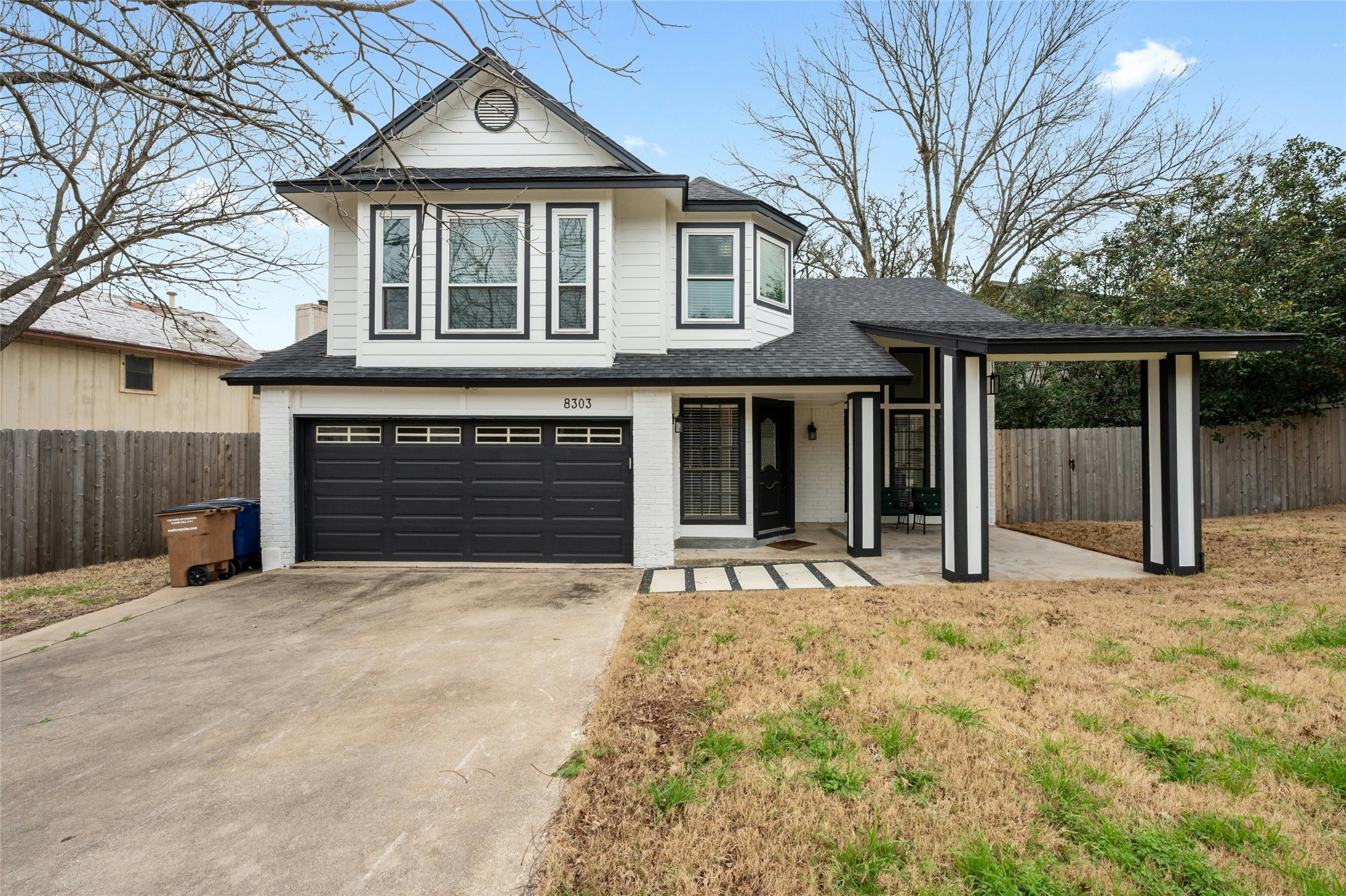 View of front of property with an attached garage, driveway, brick siding, roof with shingles, and a porch