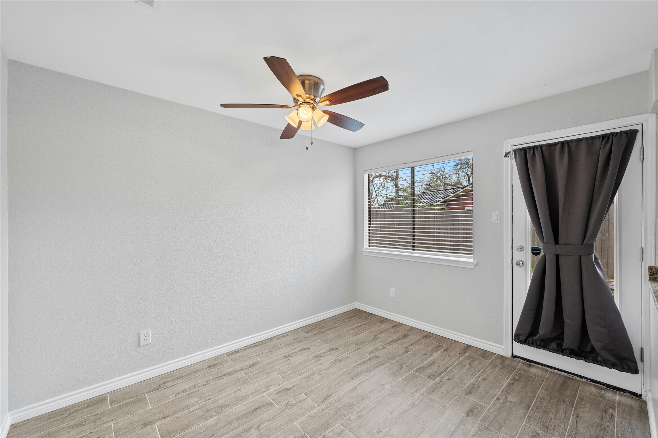 8303 Los Ranchos Drive Austin, TX 78749 - Photo 12 of 26 Empty room with wood tiled floors and ceiling fan