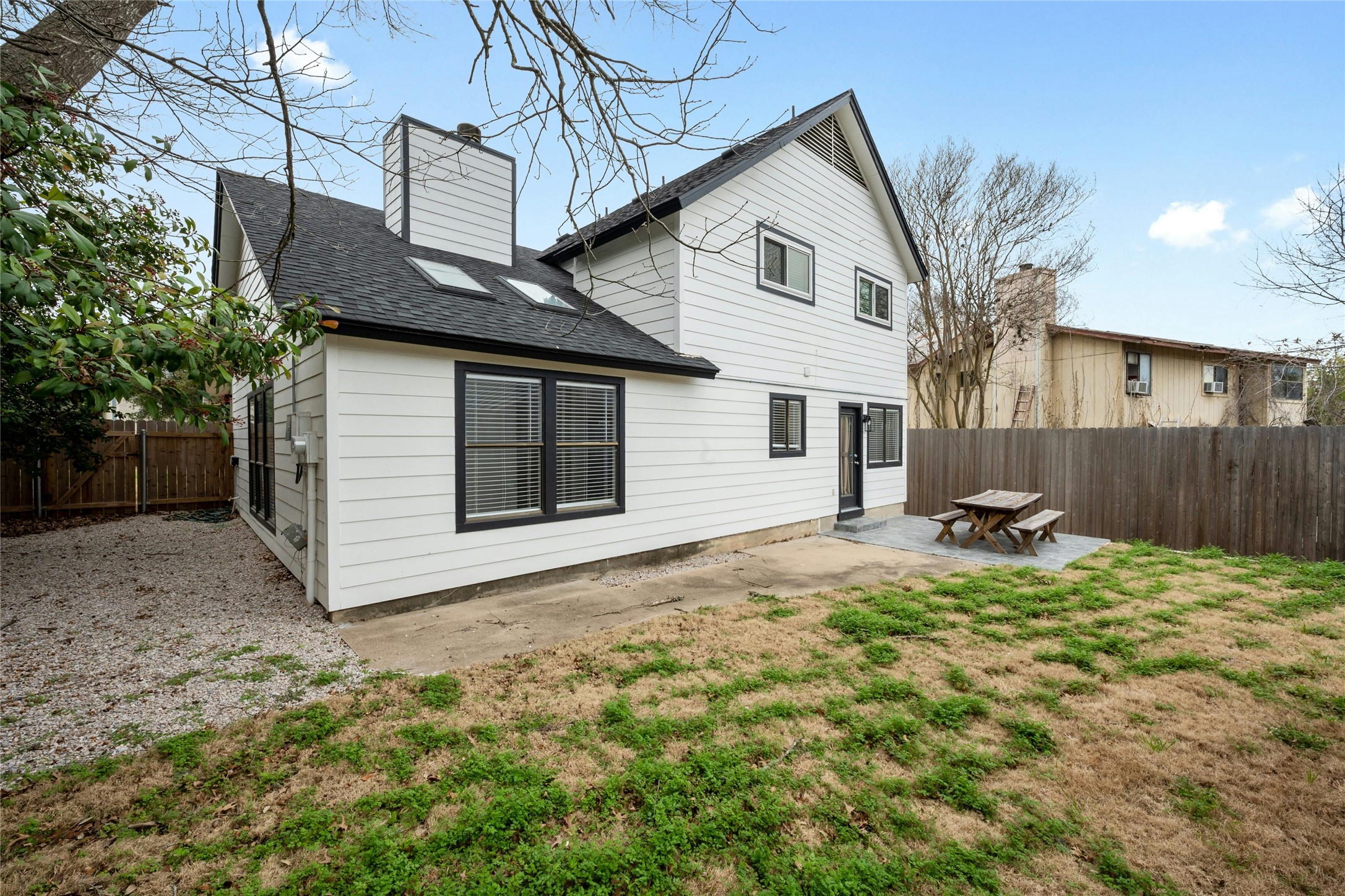 8303 Los Ranchos Drive Austin, TX 78749 - Photo 24 of 26 Rear view of property with a fenced backyard, a shingled roof, a patio, and a chimney