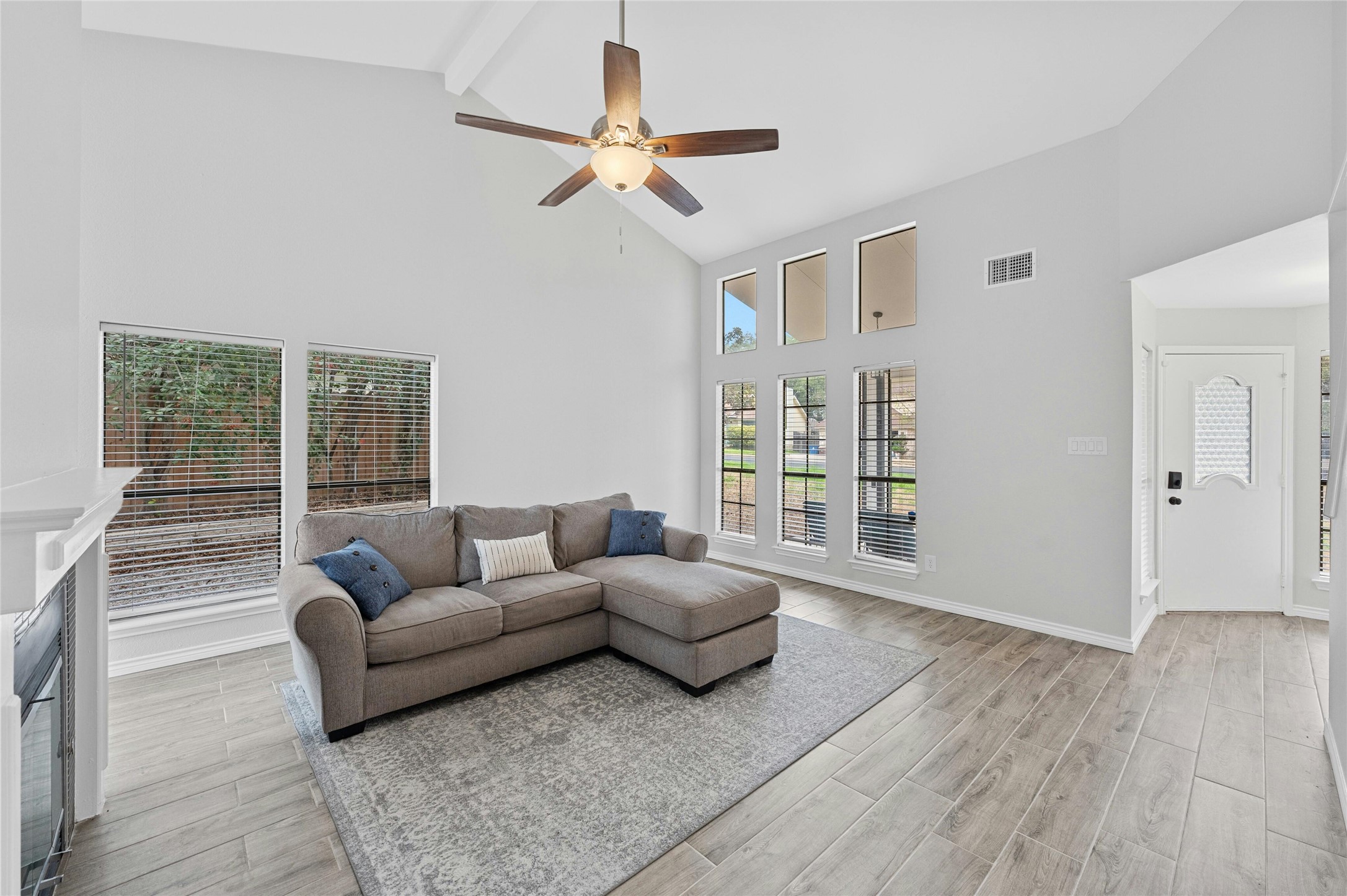 8303 Los Ranchos Drive Austin, TX 78749 - Photo 5 of 26 Living room featuring wood tiled floors, ceiling fan, and vaulted ceiling