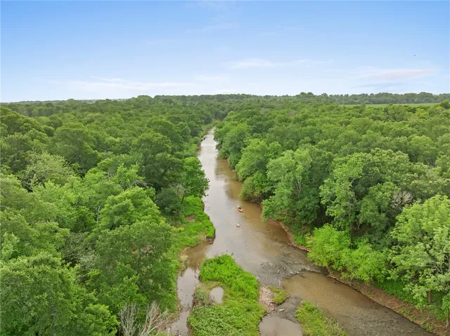 a view of a green field with lots of trees in it